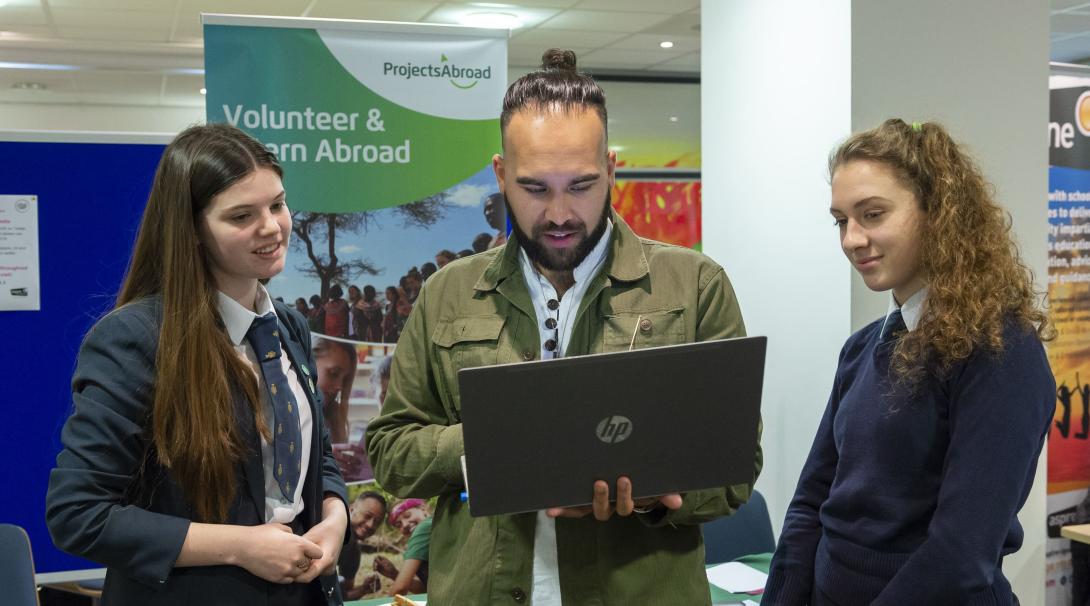 Community manager takes a student through the various volunteer opportunities available to her. Projects Abroad staff member talks to students about volunteer and internship opportunities.